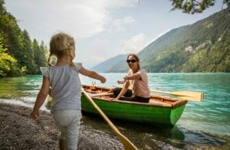 Austria, Carinthia, Weissensee, mother in rowing boat with daughter at the lakeside
