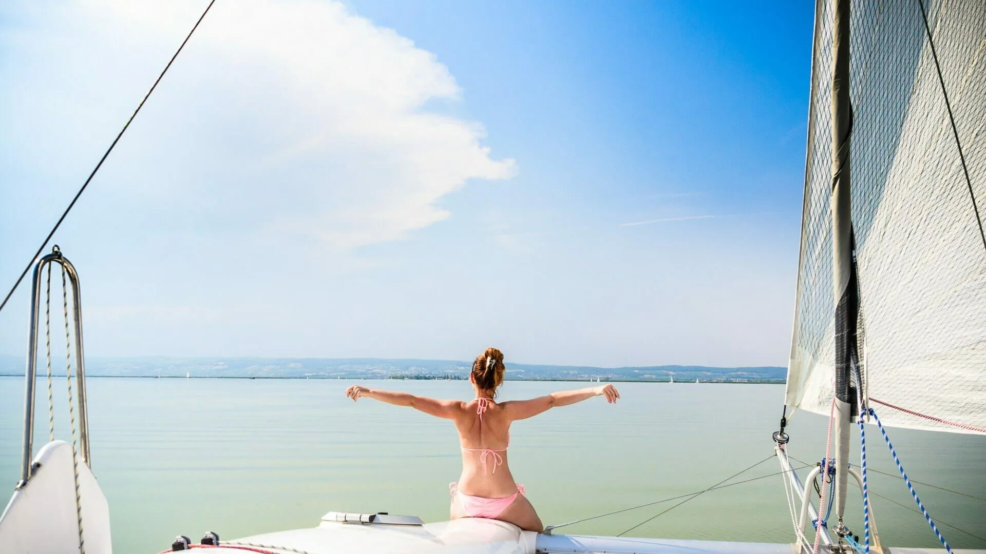 Girl on catamaran boat swims through Neusiedlersee lake