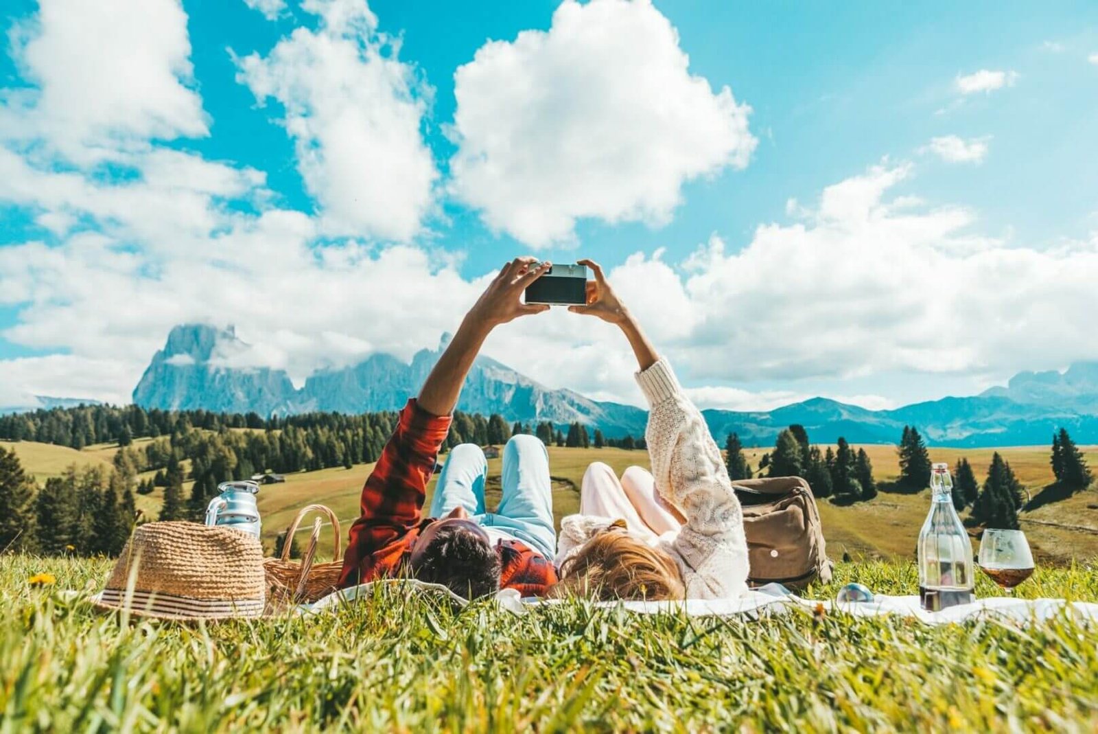 Couple of tourists lying on the grass visiting tirol alps.