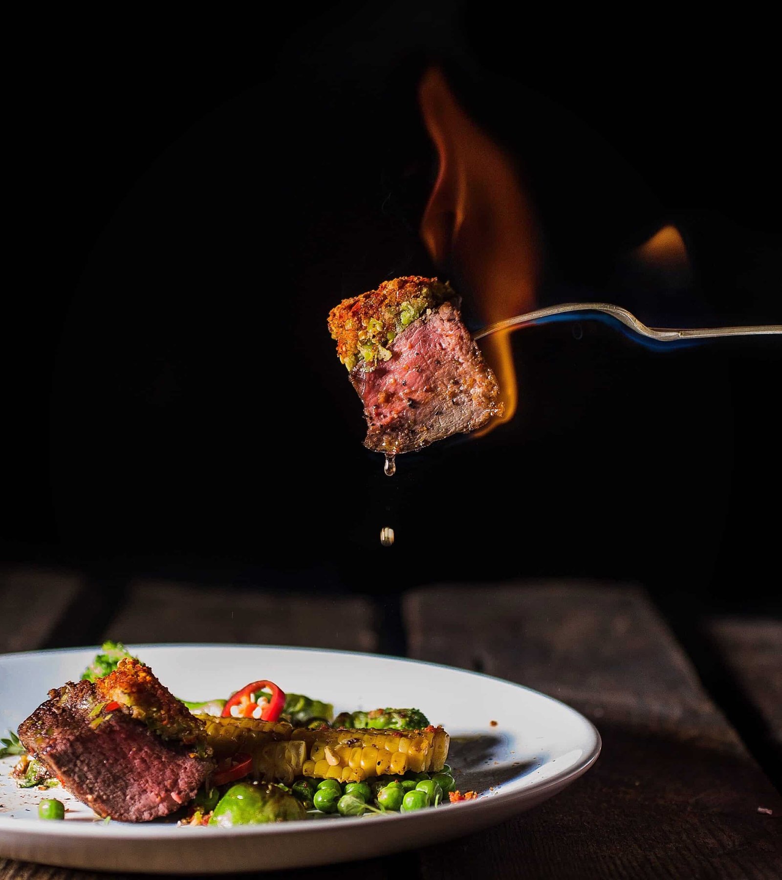Spicy meat dinner with fire in dark style