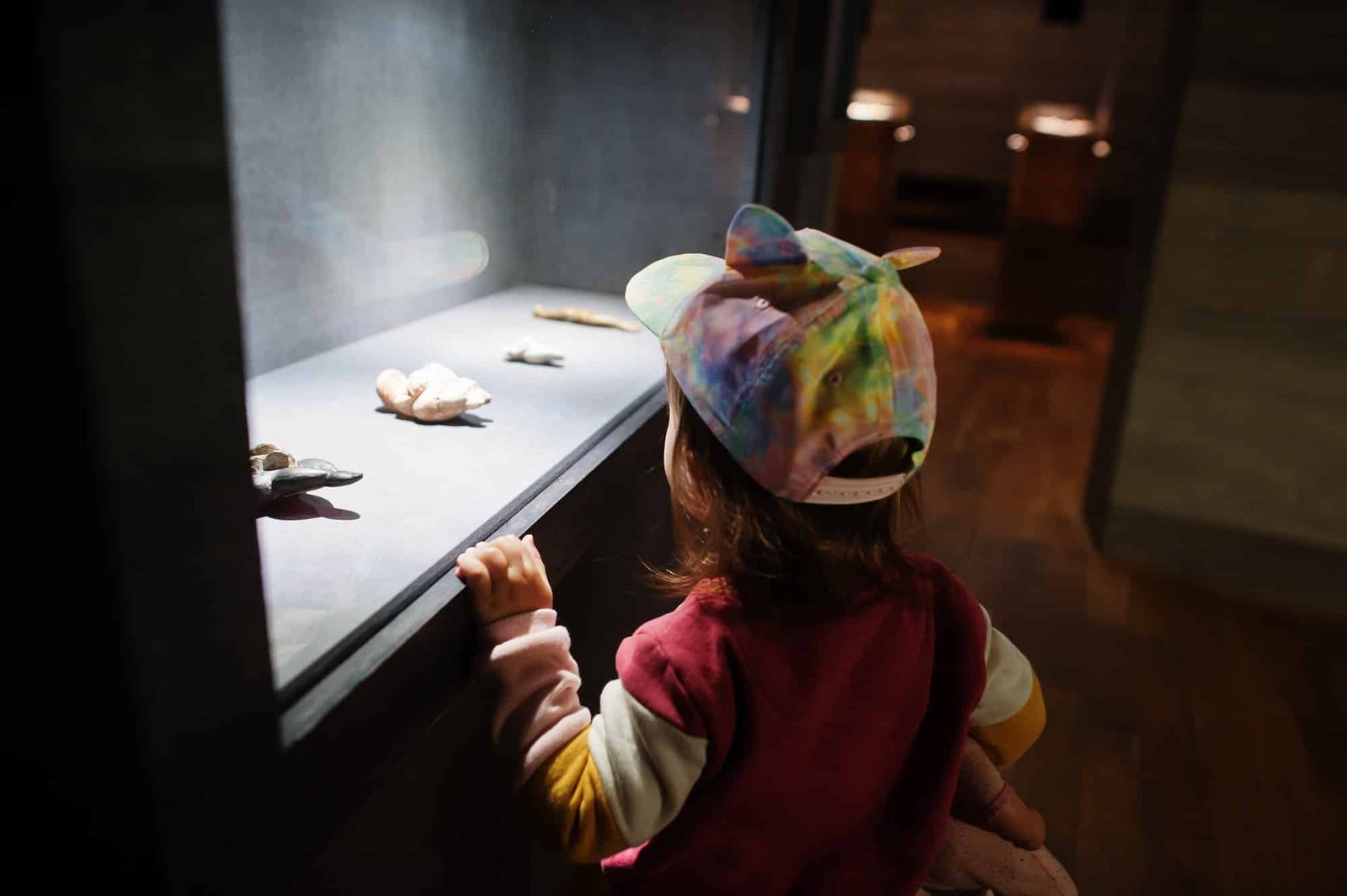 Baby girl exploring expositions in museum halls.