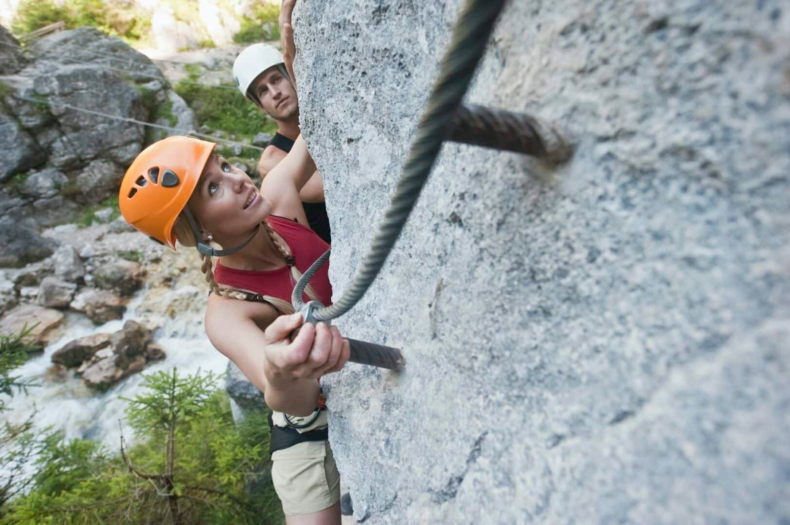 Austria, Steiermark, Ramsau, Silberkarklamm, Young couple climbing rock, looking up