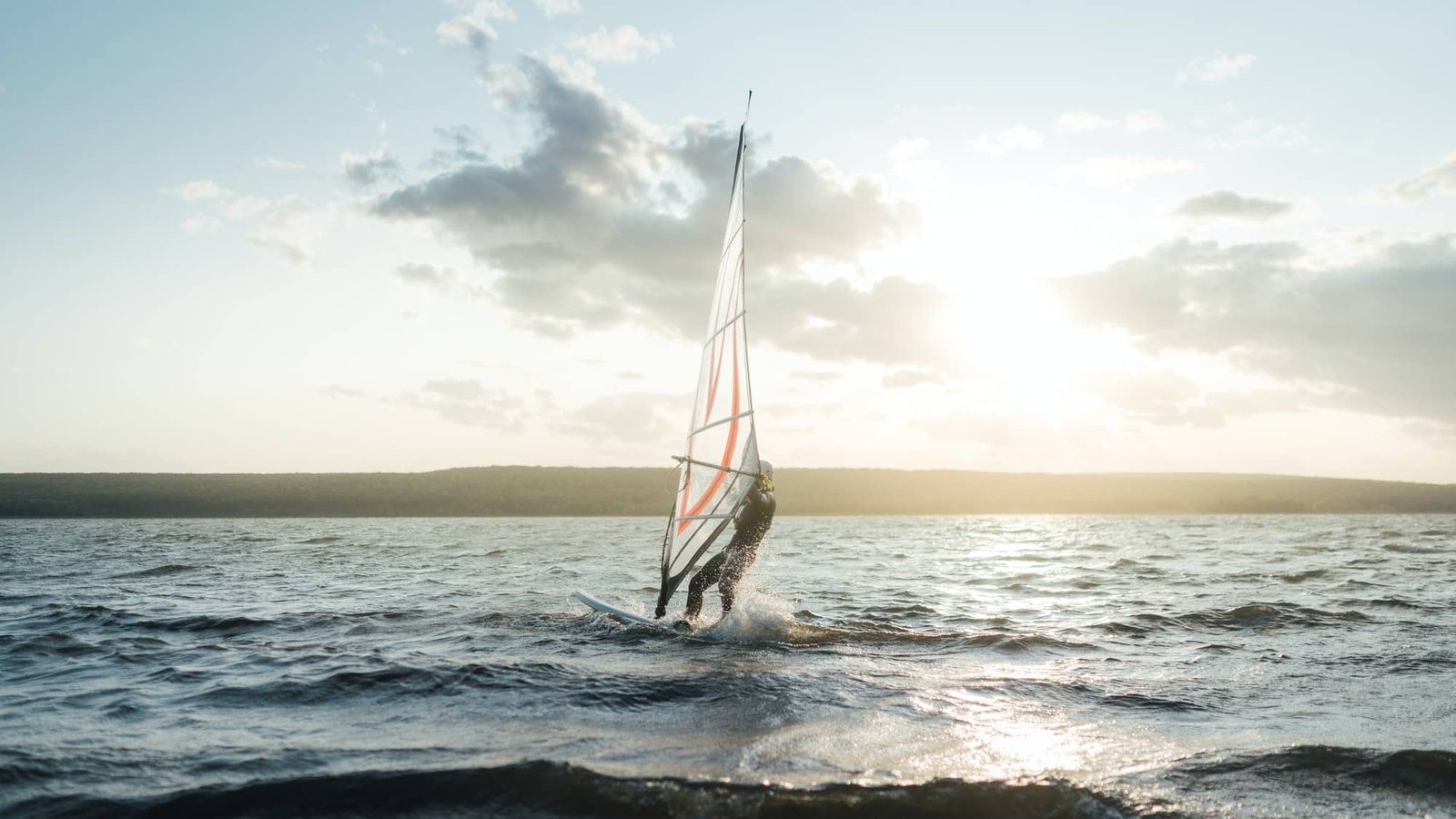 Morning windsurfing on the lake sunrise,