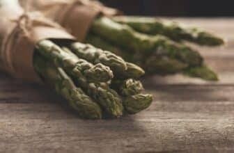 bunches of fresh green asparagus on wooden tabletop