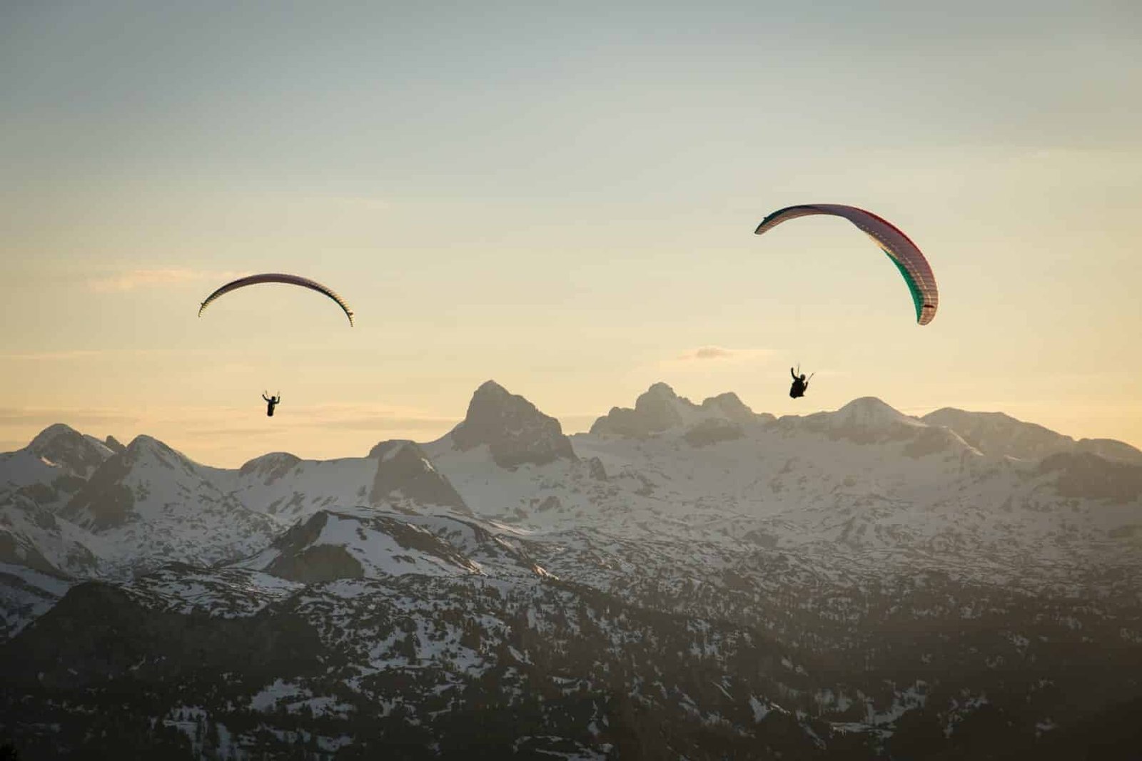 Paraglider couple flying over the mountains