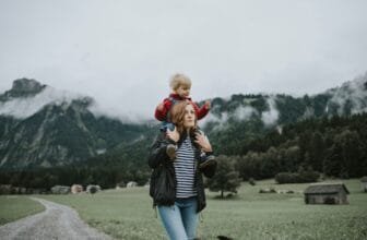 Austria, Vorarlberg, Mellau, mother carrying toddler on shoulders on a trip in the mountains