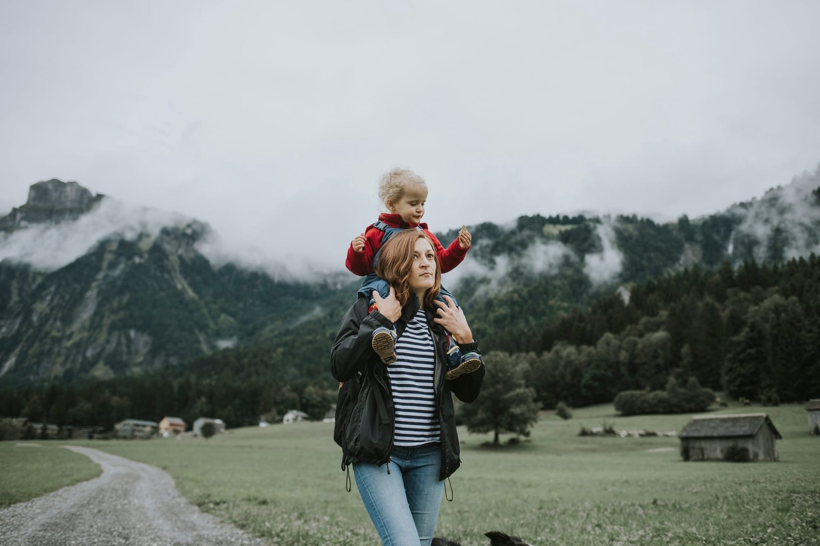 Austria, Vorarlberg, Mellau, mother carrying toddler on shoulders on a trip in the mountains