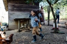 Family in a chicken pen on an organic farm