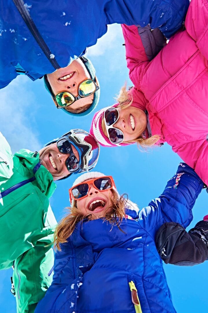 Low angle view of family in winter clothing and sunglasses